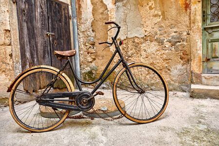 Old retro bicycle on vintage street in Croatia background aged wall and wooden door. City Lovran.の写真素材