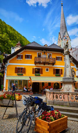 Hallstatt, Austria. Scenic postcard view of historic village town square with statue and church tower. Traditional colorful houses at Hallstatter See in Austrian Alps. Salzkammergut region.の写真素材