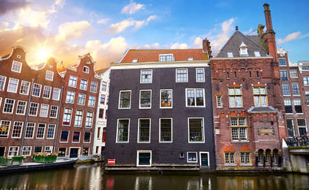 Red-light district in Amsterdam city picturesque landscape panorama evening town with pink sunset sky. Bridge over canal river Amstel.の写真素材