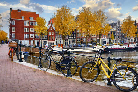 Bike over canal Amsterdam city. Picturesque town landscape in Netherlands with view on river Amstel.の写真素材