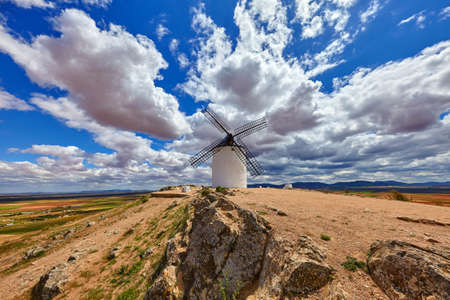 Wind mill at knolls at Consuegra, Toledo region, Castilla La Mancha, Spain. Route of Don Quixote with windmills. Summer landscape with blue sky and clouds.の写真素材