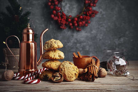 Homemade cookies with cup coffee nuts and copper coffeepot on old wooden board in rustic style. Still life with festive treats.の写真素材