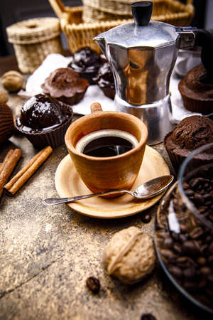 Crafting coffee in clay cup with bean cezve and chocolate cake top view on grunge background.の写真素材