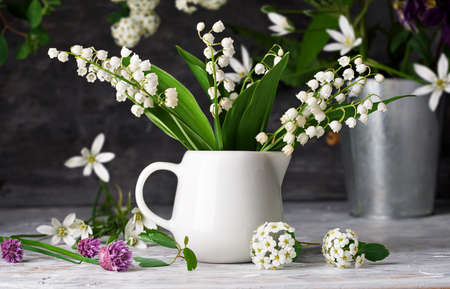 Bouquet spring white Lily of the valley. Floral still life on gray wooden board table in rustic style. Blooming branch bush with flowerbed gardening flower-growing.の写真素材