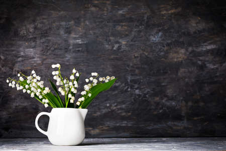 Bouquet spring white Lily of the valley. Floral still life on gray wooden board table in rustic style. Blooming branch bush with flowerbed gardening flower-growing.の写真素材