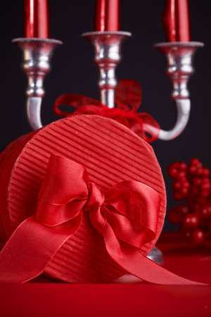 Gift in red box with bow at Valentines day with candles. Festive card.の写真素材