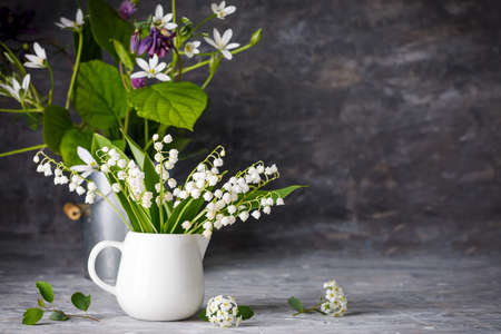 Bouquet spring white Lily of the valley. Floral still life on gray wooden board table in rustic style. Blooming branch bush with flowerbed gardening flower-growing.の写真素材