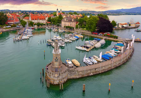 Lindau, Germany. Antique bavarian town at Lake Constance (Bodensee). Monument with statue of lion at entrance to port, yachts by piers. Summer landscape blue sky.の写真素材
