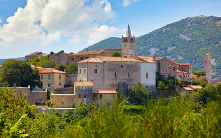 Plomin Croatia. View at old medieval town with vintage Roman tower clock. Picturesque panorama village blue sky and white clouds.の写真素材