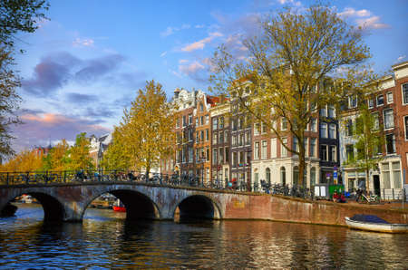 Bridge over channel in Amsterdam Netherlands houses river Amstel landmark old european city spring landscape.の写真素材