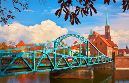 Wroclaw Poland view at Tumski island and Cathedral of St. John the Baptist with bridge through river Odra. Picturesque fall landscape autumn day blue sky with white evening clouds.の写真素材