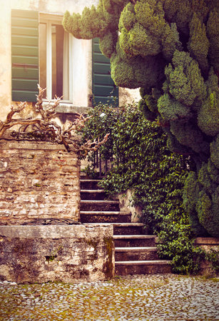 Old italian yard with wooden shutter at window house and stone stair. Verona Italy.の写真素材