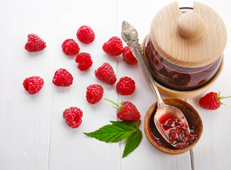Raspberry jam with berry on light background. Homemade raspberry. Banner, menu, recipe place for text, top view.の写真素材