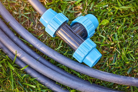 Fittings pipes and connectors for the garden and lawn irrigation system installation. Green grass, shallow depth of field. Place for text.の写真素材