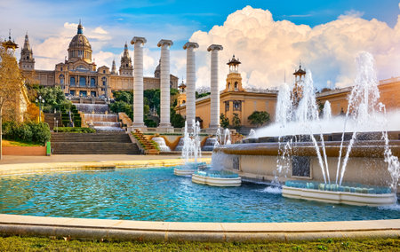 Barcelona, Spain. Magic fountain of Montjuic Mountain by the National art museum of Catalonia. Fountain pool summer day with cloudy sky.の写真素材