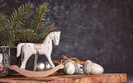 Christmas card with vintage wooden horse and acorns on a rustic wooden board. Retro decorations for christmas tree over grunge gray background.の写真素材