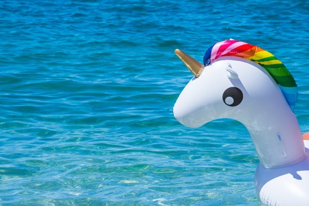 Unicorn swim tube on water background. Inflatable unicorn.Fantasy Swim Ring for Summer Pool or sea. Active funny vacation timeの写真素材
