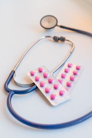 Stethoscope ,phonendoscope isolated on white background, medical equipment. stethoscope with pink pills.pharmaceutical drug, medicine concept, health businessの写真素材
