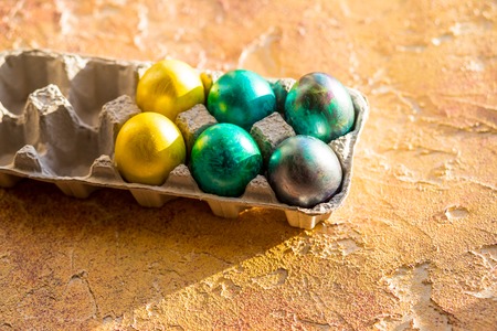 Easter eggs on yellow table. Holiday background.Corner of a tray of colorful eggs. Happy easter conceptの写真素材