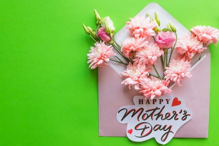 A bouquet of pink flowers, lisianthus, chrysanthemum on a green background. Happy Mothers day card. Greeting Card with Spring Bouquet.Pink chrysanthemum flowers.Happy Mothers Day Pastel Candy Colors Background.の写真素材
