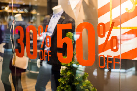 Boutique and Sale sign.Shop window display in the post about sales.announcement of a fifty-percentage discount on a glass show-window.shopping and discount concept.の写真素材