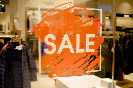 SALE Sign on the shops window display.discount sign on show window. Sale sign, symbol in clothes shop,The red announcement of a fifty-percentage discount on a glass show-window. Copy spaceの写真素材