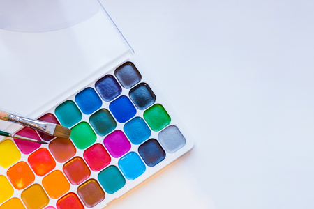 Tools for creative work on a white wooden background. Watercolor paintbox. Color paints . Back to school. Kids painting concept. Children art. Top view. Copy space.の写真素材