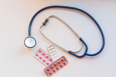 Closeup stethoscope near capsules in blister pack on white table.Top view. drug and pills with phonendoscope. Health care conceptの写真素材