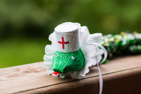 a paper snake toy isolated over a green background.medical snake caduceus handmade from paper. Hobby cocept.Selective focus.medical workers day. Doctor dayの写真素材