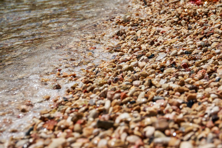 sea waves with many beautiful beach pebbles texture background.Beach with white,yellow and gray...