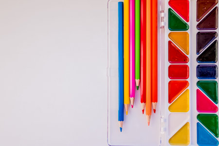 Place for text, design. The workspace of artist for drawing. Colored pencils, watercolor, paints,...