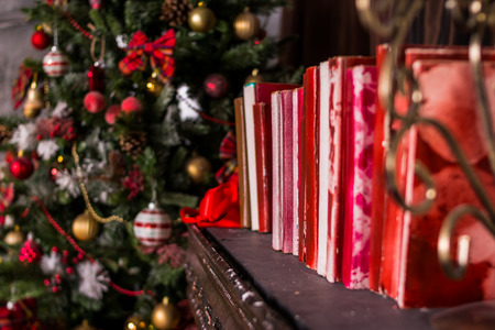 Stack of old vintage books, Winter decoration. decoration of the shelf for the new year or Christmas. candles, Christmas tree, books, craft present gift box and christmas tree decoration on wooden shelfの写真素材