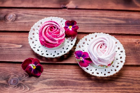 Sweet dessert white,pink zephyr marshmallows on clay plate and rustic wooden background.Marshmallow, Meringue, Zephyr. Selective focus.Copy spaceの写真素材