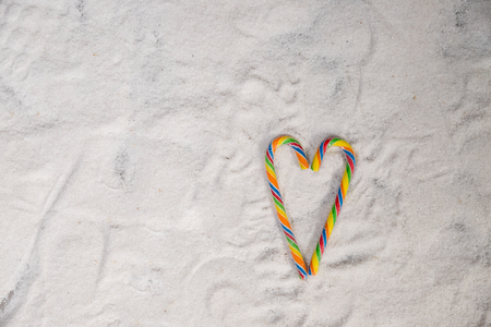 Candy canes arranged in a heart shape against white background to convey valentine concept.colorful lollipop.Candy valentines hearts.colorful christmas candy canes. Greeting card.Copy spaceの写真素材