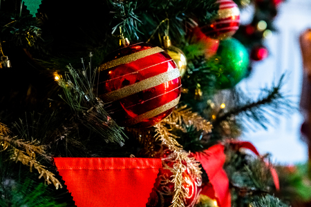 Magically decorated Christmas Tree with balls, ribbons and garlands on a blurred shiny, fairy and sparkling background.Decorated Christmas tree. Bright decorations for the New Year. Christmas decoration. Holidays Home decor.の写真素材