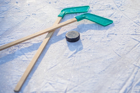 hockey stick and puck on the ice on sunny winter day.winter sports for outdoor activities.hockey...