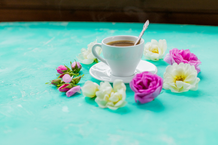 white flowers pour out from a Cup on a green background. the concept of hot drink: coffee or tea for Breakfast. minimal flat lay.の写真素材