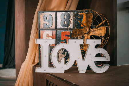 Wooden letters forming word LOVE written on wooden background. St. Valentines Day.old funny decorative dresser with numbers. Lovely old wood. old antique wooden painted chest. In the foreground a wooden inscription love. Wedding decor.の写真素材