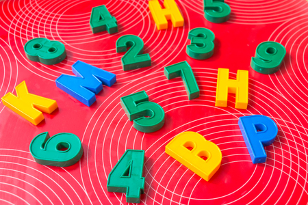 Learning elements.concept Image of magnetic numbers, education.Multicolored Alphabet letters of the English alphabet on red background. Education or business concept.Plastic Numbersの写真素材