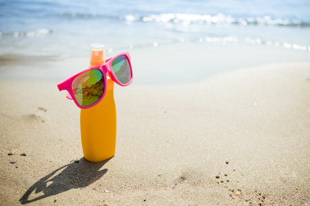 Various sunsreen products in the sand. cosmetic bottles for personal care isolated on beach...