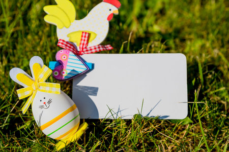 Easter greeting card mock up with bunny eggs on green grass background. Creative greeting...