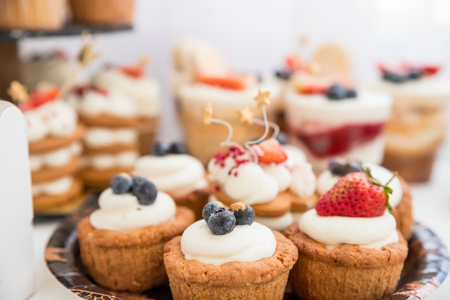 Cake with various berries and meringues on a stand.の写真素材