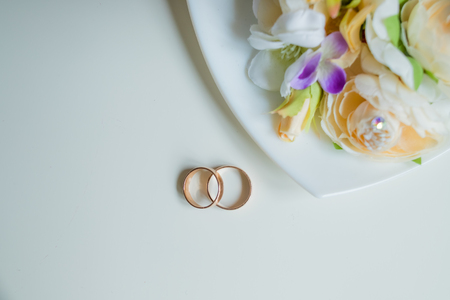 wedding ring, beautiful bouquet,bridal accessories.Wedding invitation card.Gold wedding rings with flowers and lots of copy space for text.Memmorable date organization conceptの写真素材