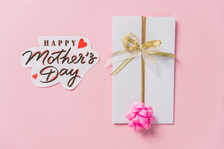 happy mother's day text, greeting card. beautiful lilac purple flowers on pink background, flat lay with space for text. modern image. top view. stylish creative floral wallpaperの写真素材