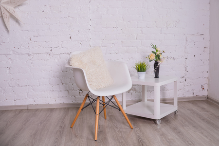 Luxury and minimalistic white home interior with chair, coffee table with tropical plant in vase. Copy space for inscription, mock up poster. Empty brick wall. Brown wooden parquet.scandinavian styleの写真素材