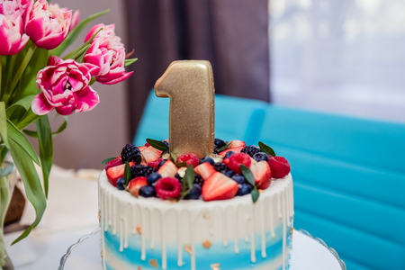 Table with sweets, Berry cake 1 year, Candy bar, Delicious sweets on candy buffet, cake with a fresh berries, childrens birthday.First birthday cake.Delicious sweet food.Copy spaceの写真素材