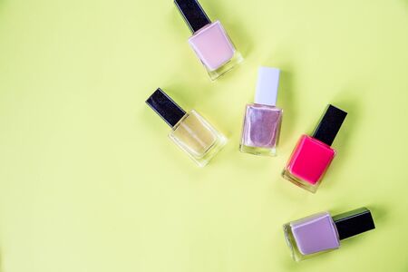 Multi-colored bottles with nail polish laid out on a yellow background.Bottle of Nail Polish. Beauty salon. Trendy Stylish Colorful Nails, Nailpolish.Manicure Beauty treatmentの写真素材