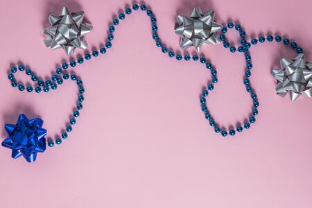Christmas composition. Christmas balls, garland, blue and silver decorations on pink background. Flat lay, top view, copy space.bows and decorations. holiday Decoration elementsの写真素材