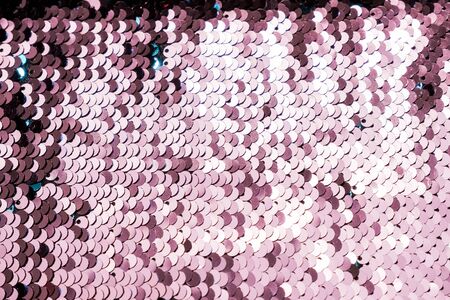 Fashion pink sequin background, fabric glitter surfactant. glitter surfactant. Holiday abstract glitter background with blinking lightsの写真素材