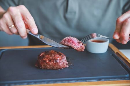 Businessman holding fork and knife eating steak, business and food.restaurant concept.eating stake from plate with fork and knife man hands.Man eating delicious juicy steakの写真素材